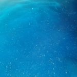 Strahlend Blaues Wasser mit leichten goldenen Glitzerpartikeln